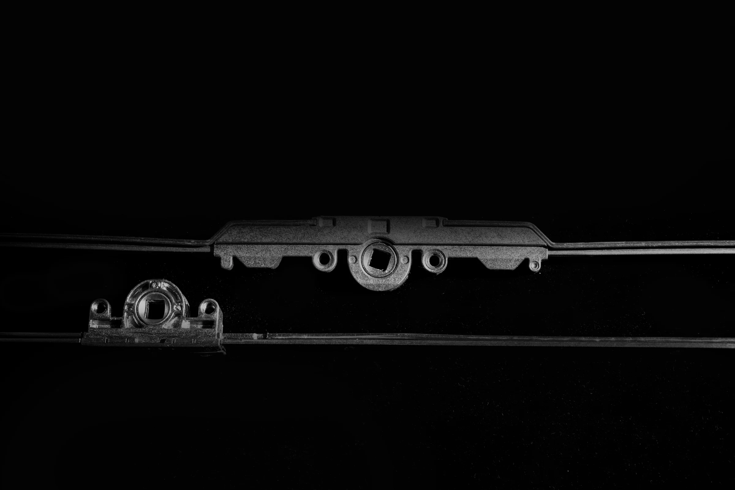 Herraje multipunto fotografiado sobre fondo negro.