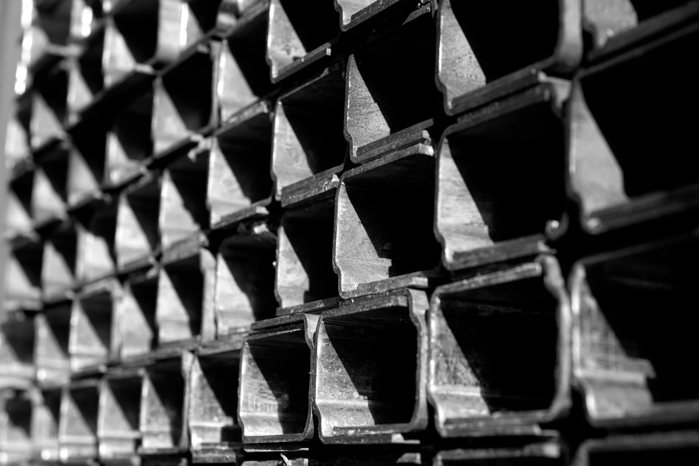 Perfiles estructurales apilados en composición monocromática.