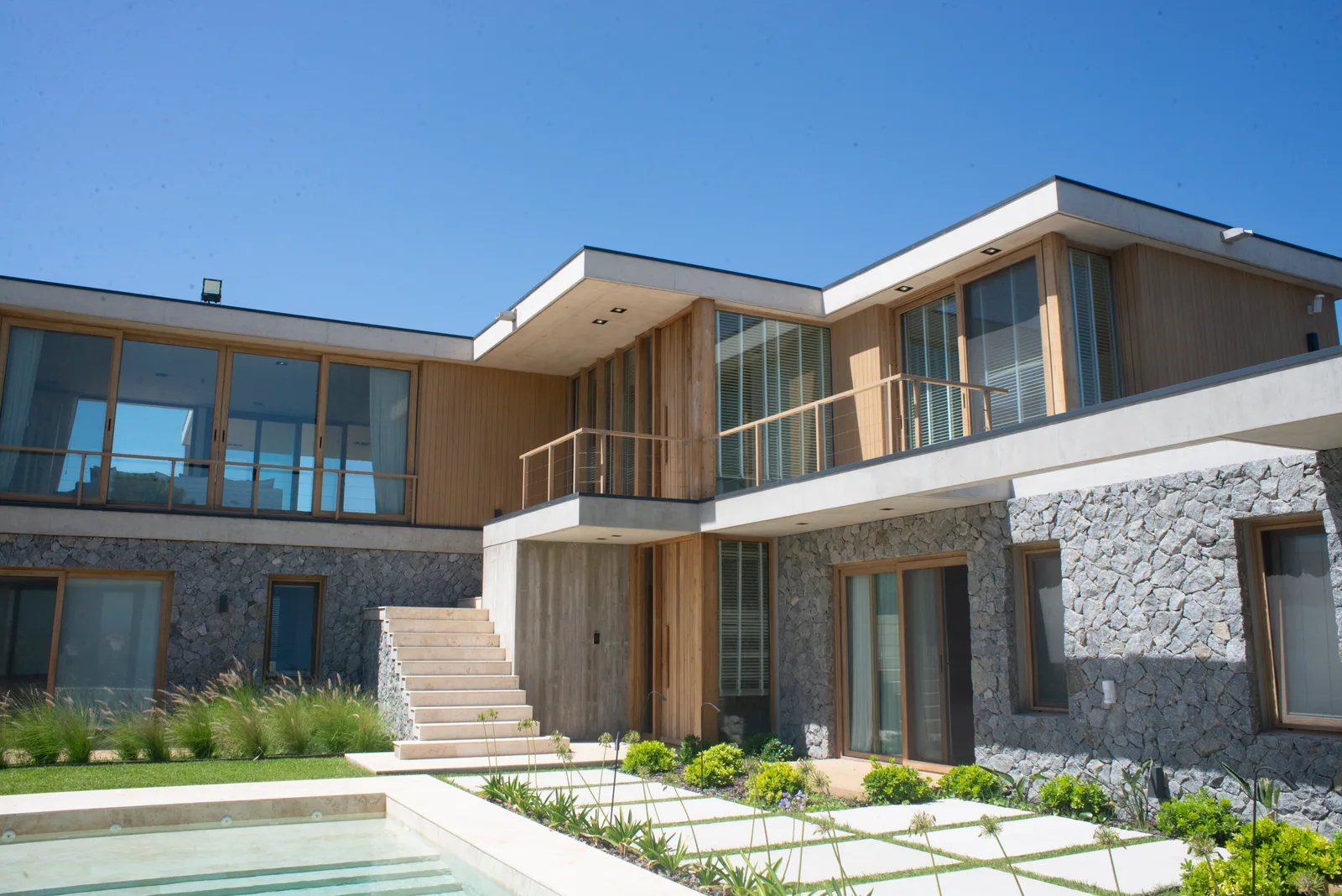 Vivienda con aberturas de PVC foliado madera y pileta